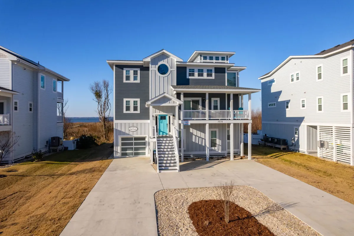 This image presents the beautiful facade of the home, showcasing its modern architecture and inviting balcony. The front steps lead up to a spacious porch, hinting at the home's upscale amenities and multiple entry points, while the balcony above suggests relaxing private outdoor spaces.