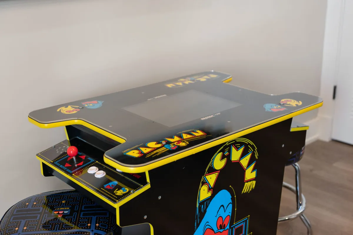 A close-up of a Pac-Man arcade game with bright, colorful controls and a nostalgic design. The image invites viewers to reminisce about classic arcade fun and offers a clear visual of the arcade element within the entertainment space.
